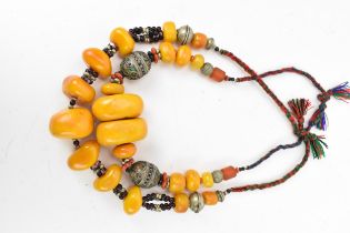 Two Moroccan Berber style pressed amber and white metal, necklaces, one with coral, and enamel to