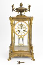 A French 19th century ormolu mounted four glass mantle clock, with central enamel dial with Roman