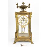 A French 19th century ormolu mounted four glass mantle clock, with central enamel dial with Roman