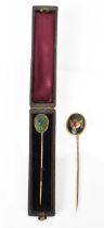 A William Essex style fox head stick pin, together with a Victorian scarab inset stick pin in fitted