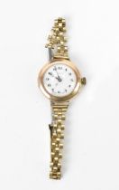 An early 20th century Rolex, manual wind, ladies, 9ct gold wristwatch, having a white dial with
