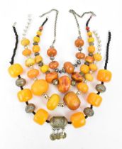 A small group of Moroccan Berber style pressed amber and white metal necklaces