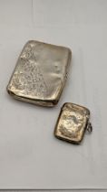 A Birmingham 1911 silver floral cigarette case, together with a silver floral engraved vesta case,