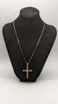 A yellow metal pendant fashioned as a cross tested as 18ct gold on a gold plated necklace, total