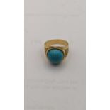 A yellow metal ring set with a circular turquoise tablet 5.3g Location: