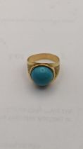 A yellow metal ring set with a circular turquoise tablet 5.3g Location: