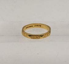 A 22ct gold wedding ring 4.45g with floral engraved detail Location: