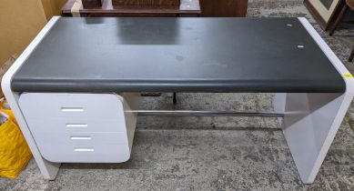An Art Deco style kneehole desk, white finished effect, black leatherette top over four side drawers