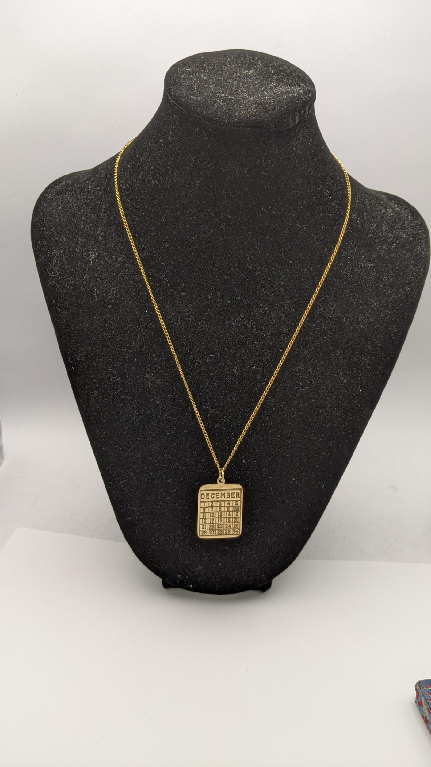 A 9ct gold calendar pendant set with a diamond on a 9ct gold necklace total weight 9.5g Location: