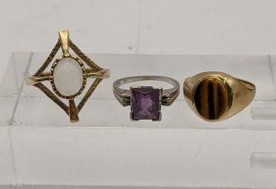 A gold coloured ring set with a tigers eye, a 9ct gold ring set with a moon stone an a white gold