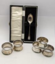 A silver spoon in a presentation box along with five napkin rings, 78.5g Location: