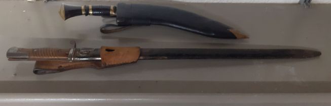 An early 20th century bayonet, together with a kukri in a leather scabbard Location:BWR