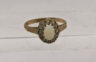 A 9ct gold ring inset with a central opal, surrounded by paste stones, total weight 2.3g Location: