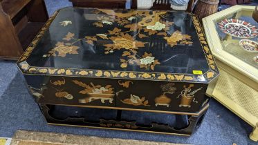 An Oriental black lacquered octagonal coffee table, the top decorated with birds amongst flowers and