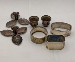 A pair of white metal Danish candleholders, together with two silver napkin rings, and a white metal