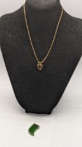 A 9ct gold chain along with a jadeite tooth shaped pendant. 8.3g Location: