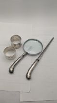Silver to include two napkin rings 47.5g, a silver handled magnifying glass and letter opener