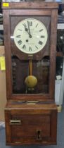 An early/mid 20th century oak carved clocking-in clock, the dial inscribed Boyhan Office Furniture