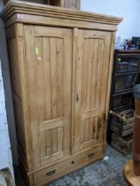A Victorian pine twin door wardrobe, stepped cornice above twin panel fielded doors, above a base