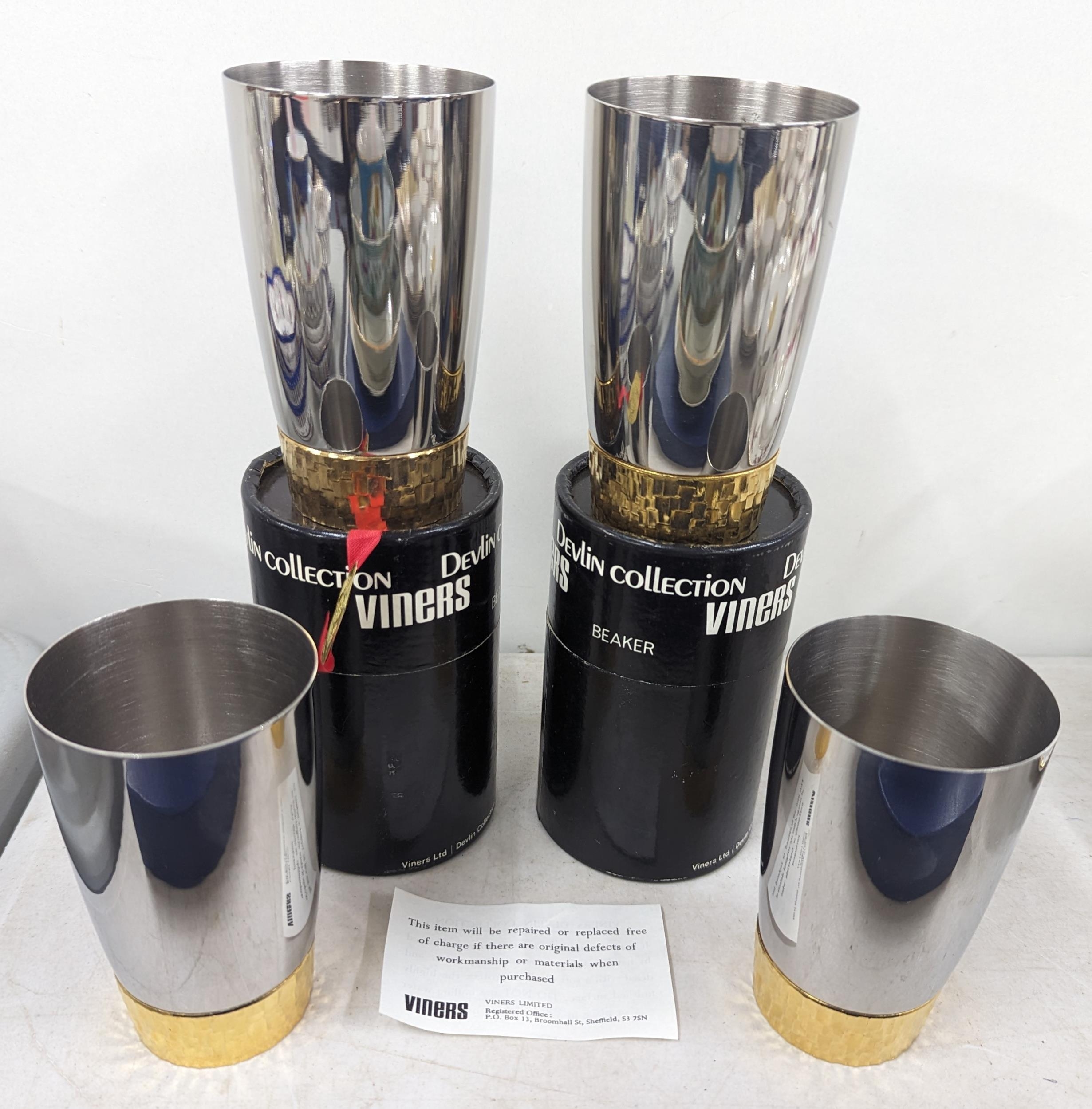 Stuart Devlin for Viners, a group of four stainless steel and gilt metal beakers, two with