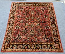 A machine woven red ground rug having a floral design and multi-guard borders, 163cm x 136cm