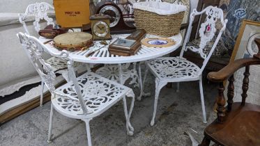 A white painted metal garden table with pierced decoration, circular top with central parasol