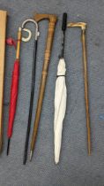 Walking sticks and umbrellas to include an early 20th century horn handled stick with a white
