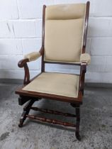 A late 19th century American walnut framed rocking chair with an upholstered back seat Location: