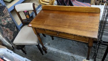 An early 20th century oak side table with extended back, a single frieze drawer on octagonal