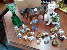 A Baron Barnstaple green glazed pottery model of a cat, a Beswick mare, a G. Hill pottery cat and