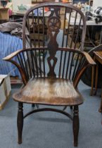 A 19th century elm seated Windsor armchair having a pierced splat back with spindle supports and a
