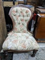 A Victorian mahogany upholstered nursing chair with carved decoration and turned front legs