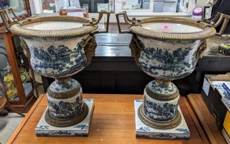 A pair of modern Chinese style pedestal vases with brass mounts decorated with landscapes in blue
