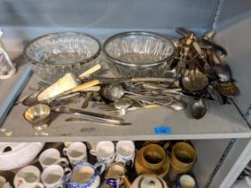 Silver plated items to include assorted cutlery, a knife rests, and two glass bowls with silver