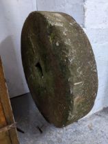 A weathered mill stone, 52cm diameter, 12cm deep, Location:G