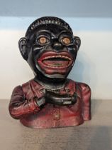 A vintage painted cast metal money box/bank in the form of an outdated depiction of an African