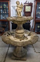 A large weathered cast stoneware fountain having a cherub to the top above two graduated shell