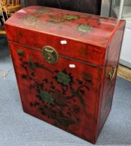 A late 20th century oriental red lacquered chest with a hinged, domed top, decorated with flowers