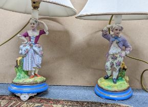 A pair of late 19th/early 20th century Continental porcelain figural table lamps on blue painted