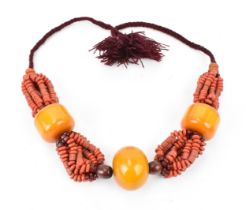 A Moroccan Berber style pressed amber and coral bead necklace, with braided wool fastening,