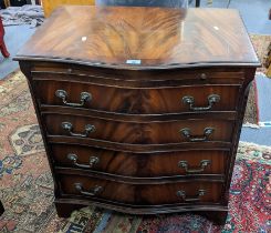 A late 20th century mahogany finished, serpentine fronted chest with a brushing slide and four