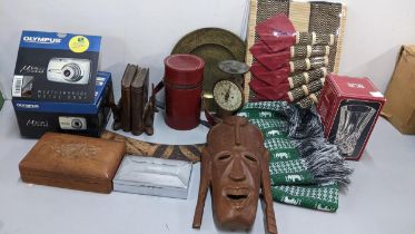 A mixed lot to include a boxed Olympus camera, tribal mask, silver plated cigarette box, bookends,