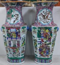A pair of 20th century Chinese Famille rose vases, painted with scenes of figures, birds, and lion
