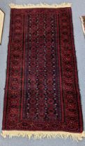 A Persian hand woven rug having a red ground, repeating motifs and tasselled ends, 157cm x 82cm