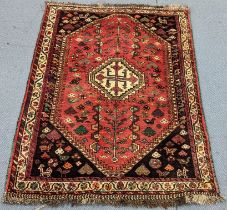 A Persian Shiraz rug having a central motif, lozenge-shape field, tree motifs with small animals and