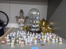 A collection of porcelain thimbles some in domed display case, a Dresden style vase and cover