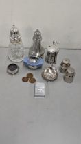 A mixed lot to include a silver lidded sugar caster, silver salts, silver plated salt and pepper pot