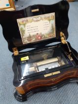 A late 20th Century Reuge music box in a walnut and mixed wooden case playing 4 songs. Location:RAM