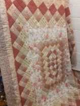 A late 20th Century shop bought and machine made patchwork quilt 75" x 102" in pinks, greens,