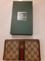 Gucci- A vintage Gucci 'Sherry Line' leather and canvas purse/wallet having a gold tone double GG to